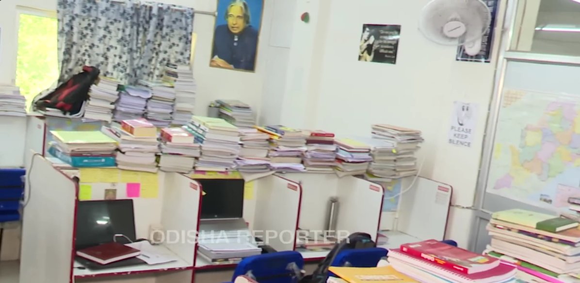 Inside a private reading hub in Bhubaneswar — individual cubicle desks, study material, PLEASE KEEP SILENCE sign